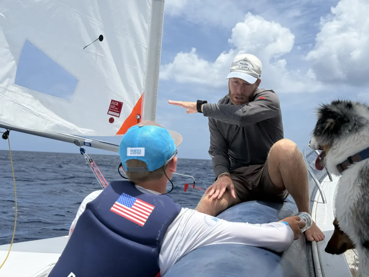 Coach briefing young sailors from the coach boat